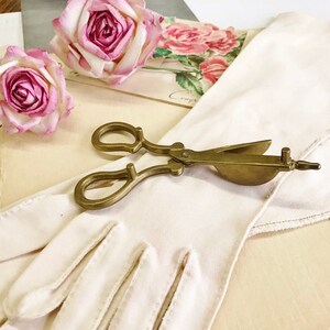 Where can you buy a vintage BRASS CANDLE SNUFFER SciSSors?  Here and it's in GREAT condition and perfect for snuffin' out wicks on candles!  It's so much nicer than burning your fingers. It's FooTeD and has a great gothic or Victorian look and would make a great photography prop.  
I always called this tool a SNUFFER OUTER but did ya know another word for snuffer is Douter?