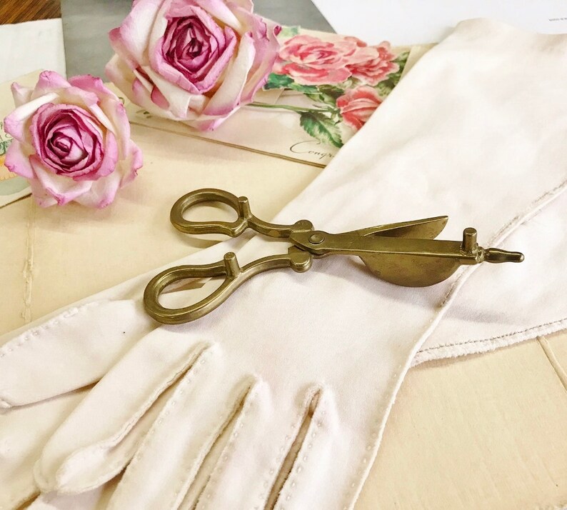 Where can you buy a vintage BRASS CANDLE SNUFFER SciSSors?  Here and it's in GREAT condition and perfect for snuffin' out wicks on candles!  It's so much nicer than burning your fingers. It's FooTeD and has a great gothic or Victorian look and would make a great photography prop.  
I always called this tool a SNUFFER OUTER but did ya know another word for snuffer is Douter?