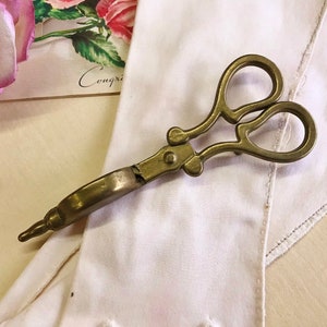Where can you buy a vintage BRASS CANDLE SNUFFER SciSSors?  Here and it's in GREAT condition and perfect for snuffin' out wicks on candles!  It's so much nicer than burning your fingers. It's FooTeD and has a great gothic or Victorian look and would make a great photography prop.  
I always called this tool a SNUFFER OUTER but did ya know another word for snuffer is Douter?