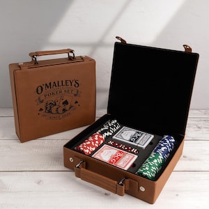 May include: A tan leatherette poker set case with a handle and the text O'MALLEY'S POKER SET SINCE 2026. The open case reveals black foam inserts holding stacks of red, white, blue, and green poker chips, two decks of BCG playing cards, and dice.