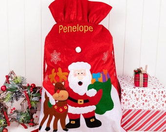 May include: Red Christmas gift sack with the name "Penelope" embroidered in gold. The sack features an illustration of Santa Claus, a reindeer, and a stocking filled with gifts. The words "Love from Santa x" are printed at the bottom.
