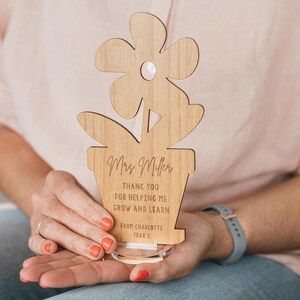May include: Wooden flower pot teacher appreciation award with the text "Mrs. Miller Thank you for helping me grow and learn from Charlotte Year 2".