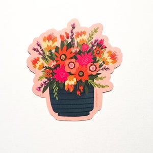 May include: A sticker featuring a colorful bouquet of flowers in a blue and white striped pot. The flowers are red, orange, yellow, pink, and purple.