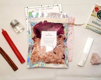 May include: Self-love ritual kit with pink Himalayan bath salts, rose petals, a red candle, a cinnamon stick, a clear glass bottle, a selenite wand, a rose quartz crystal, and a packet of organic hibiscus tea.