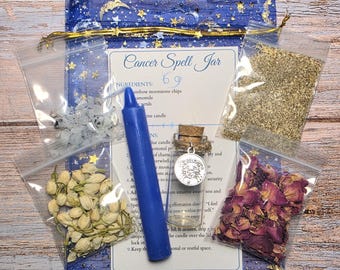 May include: A Cancer Spell Jar kit with a blue drawstring bag, a blue candle, and small bags of ingredients. The kit includes a small glass bottle with a charm, dried rose petals, and a printed instruction sheet. The text "Cancer Spell Jar" is visible.