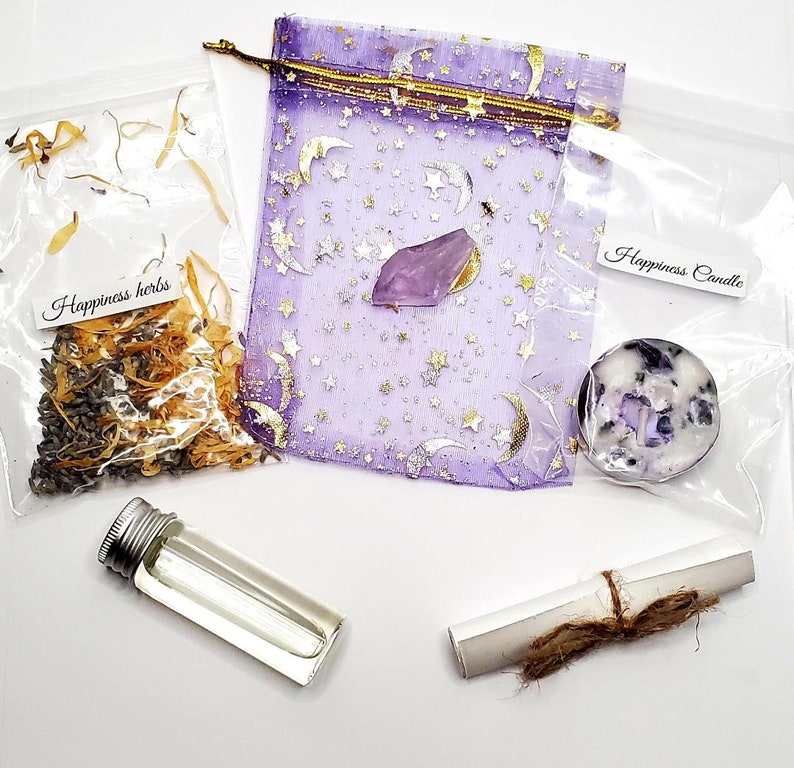 May include: A collection of spiritual items, including a small bottle, a scroll tied with twine, a purple pouch with gold stars and moons, a crystal, a candle, and a bag of herbs. The bags are labeled "Happiness herbs" and "Happiness Candle".