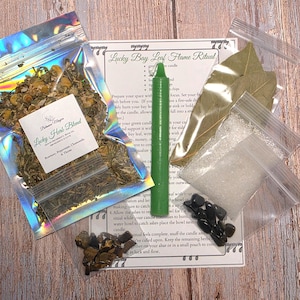 May include: A ritual kit containing a holographic pouch of dried herbs labeled Lucky Herb Blend, a green taper candle, a clear bag of bay leaves, a bag of white crystals, a bag of black stones, and an instruction sheet titled Lucky Bay Leaf Flame Ritual.