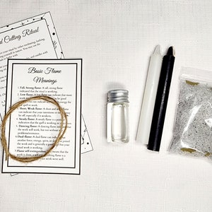 May include: A kit for a card cutting ritual with instructions, a white candle, a black candle, a small bottle of oil, a bag of white crystals, and a length of twine.