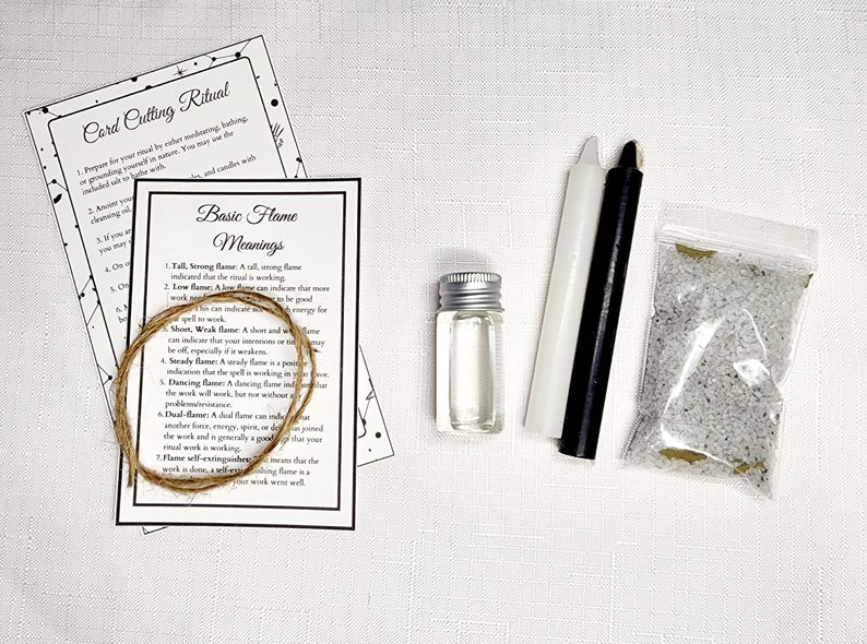 May include: A kit for a card cutting ritual with instructions, a white candle, a black candle, a small bottle of oil, a bag of white crystals, and a length of twine.