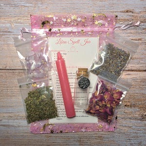 May include: A Libra Spell Jar kit with a pink candle, small glass bottle, dried rose petals, lavender, and other ingredients. The kit includes a pink mesh bag with gold stars and a card with instructions.