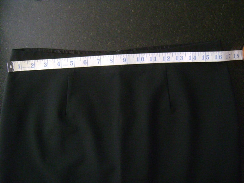 May include: Black skirt with a measuring tape showing the length is 18 inches.