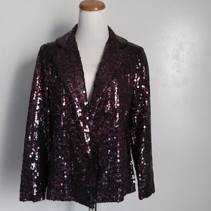 May include: A black sequined blazer with a v-neck and long sleeves. The sequins are a mix of black, purple, and pink.