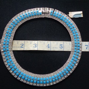 Puede incluir: Un collar de color turquesa y tono plateado con un dise&ntilde;o cuadrado. El collar mide 12,7 cm de di&aacute;metro.