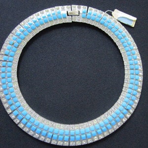 Puede incluir: Un collar gargantilla de plata y pedrer&iacute;a azul. El collar est&aacute; hecho de peque&ntilde;as piedras cuadradas de pedrer&iacute;a, alternando plata y azul.