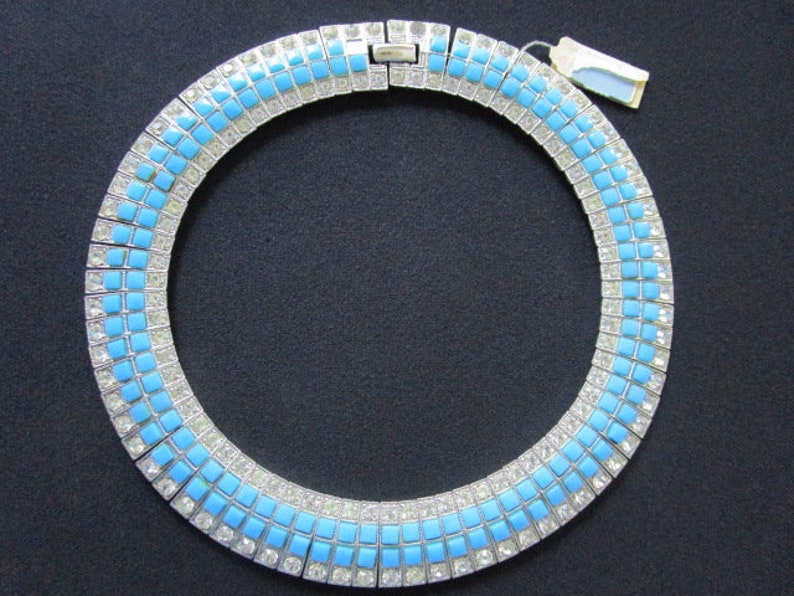 Puede incluir: Un collar gargantilla de plata y pedrer&iacute;a azul. El collar est&aacute; hecho de peque&ntilde;as piedras cuadradas de pedrer&iacute;a, alternando plata y azul.