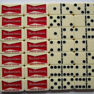 May include: A set of dominoes with black dots on white tiles. The dominoes are arranged in a grid pattern. The tiles are surrounded by red and white tiles with the text "Budweiser King of Beers" printed on them.