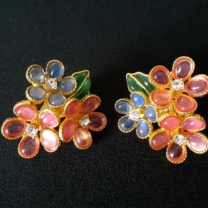 May include: A pair of gold tone earrings with a cluster of pink, blue, and green flowers. Each flower has a rhinestone in the center.