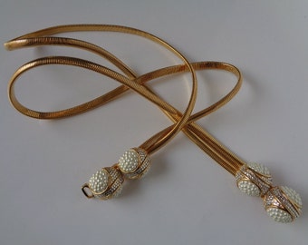 May include: A gold chain belt with two round pearl and rhinestone embellishments.
