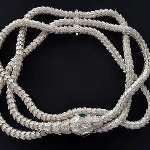 Peut inclure: Un collier de serpent en argent avec un corps serti de diamants et des yeux d'&eacute;meraude verts. Le collier est compos&eacute; de plusieurs rangs de diamants li&eacute;s.