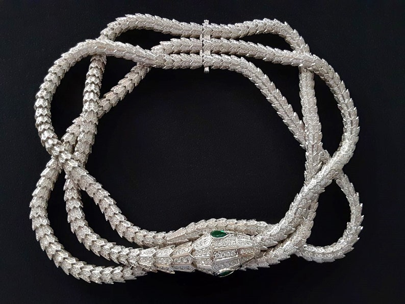 Peut inclure: Un collier de serpent en argent avec un corps serti de diamants et des yeux d'&eacute;meraude verts. Le collier est compos&eacute; de plusieurs rangs de diamants li&eacute;s.