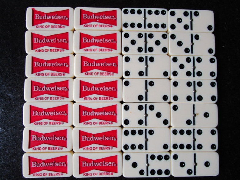 May include: A set of dominoes with white tiles and black dots. The dominoes are arranged in a grid pattern. The dominoes are surrounded by red and white Budweiser beer labels.