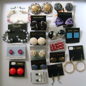 Könnte beinhalten: Eine Auswahl an Ohrringen in verschiedenen Stilen und Farben, darunter Perlen, Schwarz, Rot und Blau. Die Ohrringe werden auf kleinen Karten mit den Worten "Fashion Earrings" und "Earrings" präsentiert.