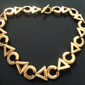 Modern-Vintage ANNE KLEIN Jewelry Triangle Circle Geometric Designs Gold Tone Toggle Clasp Collar Necklace W/ Iconic AK Lion Head Face Logo