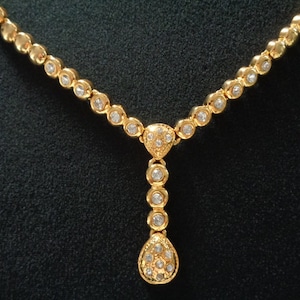 Peut inclure: Un collier en or avec un pendentif en forme de larme, tous deux ornés de pierres de zircone cubique transparentes.