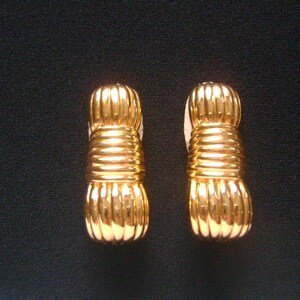 May include: A pair of gold-tone earrings with a twisted rope design.