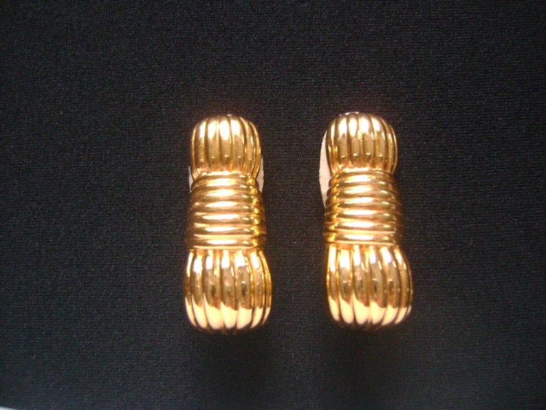 May include: A pair of gold-tone earrings with a twisted rope design.