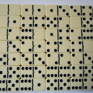 May include: A set of 18 dominoes with black dots on a white background. The dominoes are arranged in a grid pattern.