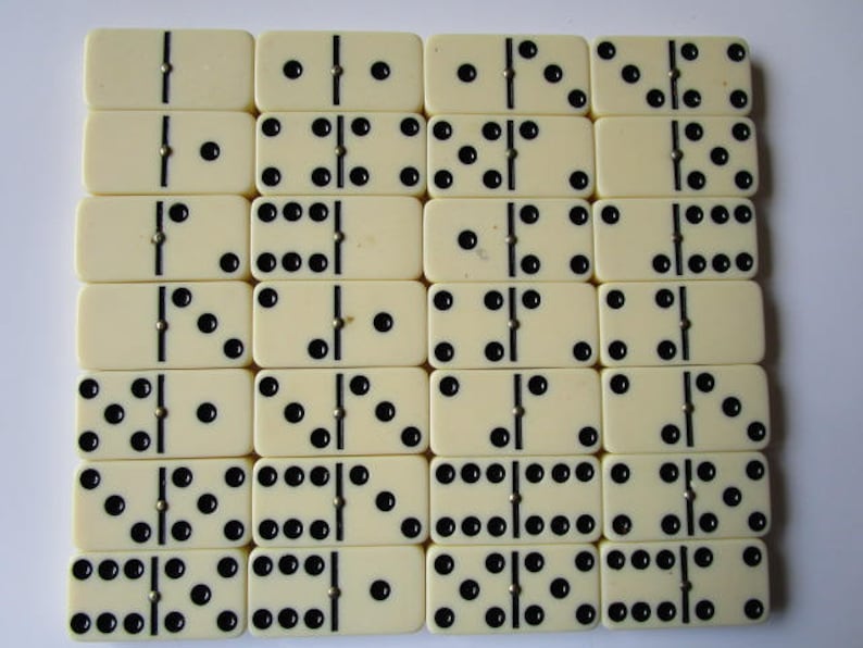 May include: A set of 18 dominoes with black dots on a white background. The dominoes are arranged in a grid pattern.