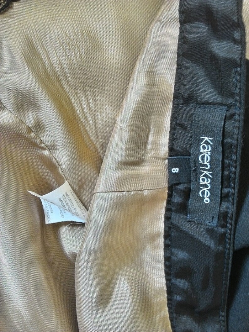 May include: A black skirt with a beige lining and a Karen Kane label. The size tag shows size 8.