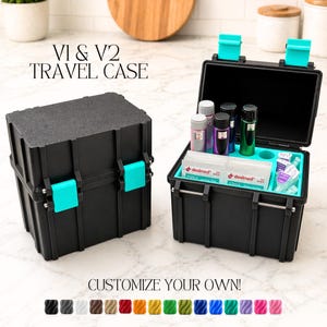 May include: Two black travel cases with teal accents. One case is closed, the other is open, revealing various small bottles and containers. The text "V1 & V2 TRAVEL CASE" is at the top, and "CUSTOMIZE YOUR OWN!" is at the bottom.