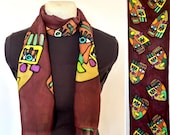 Hand-drawn and dyed Habotai silk scarf with multicolored stylized faces on a deep merlot background, 15x60