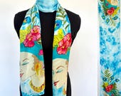 Flat crepe silk scarf with hand-painted bust of a woman with tropical headdress on a blue watercolor style background  14x72"