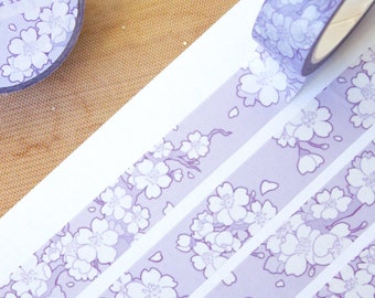 May include: Three rolls of purple washi tape with a white floral pattern. The tape is labeled "Sakura Branches" and "Washi Tape 1.5cm x 10m".