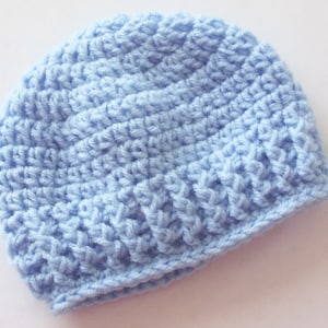 May include: A light blue crocheted beanie hat. The hat is made with a textured stitch pattern.