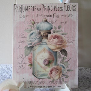 May include: A vintage-style illustration of a perfume bottle with a blue and gold stopper, surrounded by pink and blue roses. The text reads "Parfumerie au Principe des Fleurs de J. Giraud Fils, Noul Gil 1907, Grasse, Parf, Parfumeur Savonnier Distillateur, 41 Boulevard de la Gare, 41 (XI)"