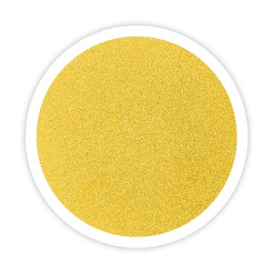 May include: A close-up of a round, yellow glitter sticker. The sticker has a white border and a textured surface.