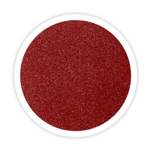 May include: A close-up of a red glitter, which is a fine, sparkly material often used for crafts and decorations.