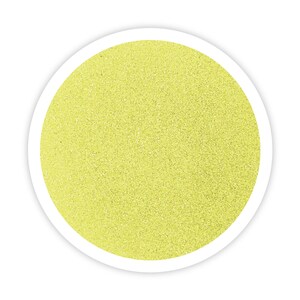 May include: A close-up of a round container filled with fine, light yellow glitter.