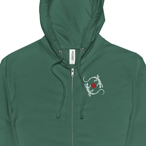 May include: A dark green zippered hoodie with a white embroidered design of two lizards circling a red rose on the left chest.