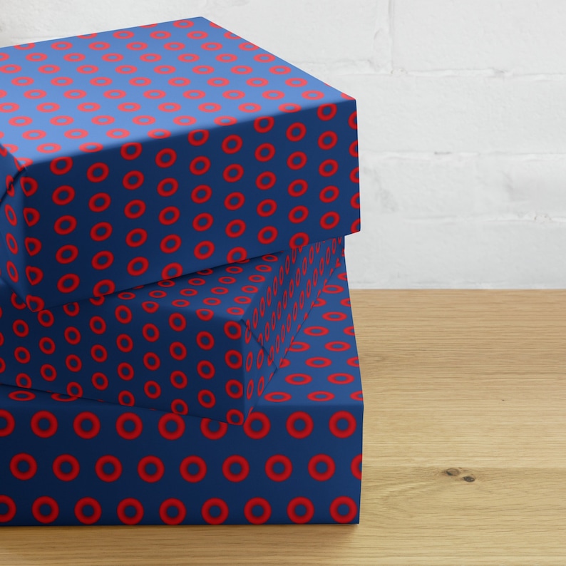 May include: Three blue gift boxes with a red donut pattern. The boxes are stacked on top of each other.