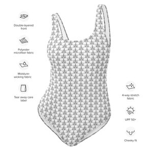 May include: White one-piece swimsuit with a repeating black geometric pattern. The swimsuit features a scoop neck and a cheeky fit. Made with double-layered front, polyester microfiber fabric, and moisture-wicking fabric. It has a UPF 50+ rating and 4-way stretch fabric.