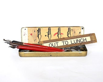 Vintage Mars Staedtler Pencil Box con plumas de inmersión de caligrafía y puntas de caza Speedball y letrero de salida para almorzar - Decoración decorativa divertida del escritorio de la oficina