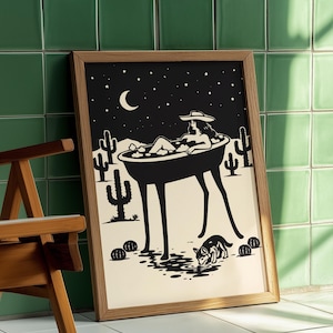 May include: Black and white art print in a wooden frame. The illustration depicts a person relaxing in a bathtub under a starry night sky with a crescent moon. Cacti and a dog are also featured in the desert scene.