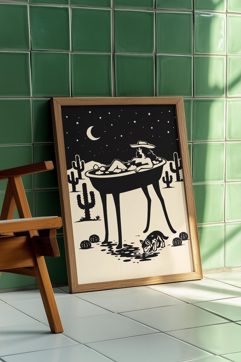 May include: Black and white art print in a wooden frame. The illustration depicts a person relaxing in a bathtub under a starry night sky with a crescent moon. Cacti and a dog are also featured in the desert scene.