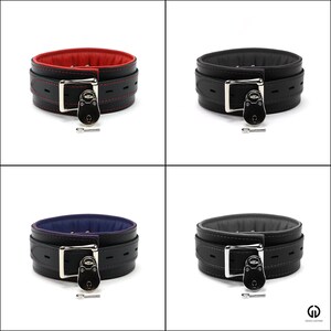 May include: Four leather collars with a silver lock and key. The collars are black with red, blue, and black lining.