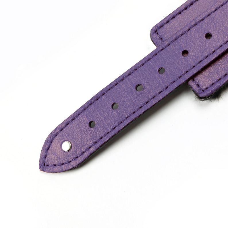 May include: Purple leather wrist cuff with silver metal accents and a fuzzy trim.